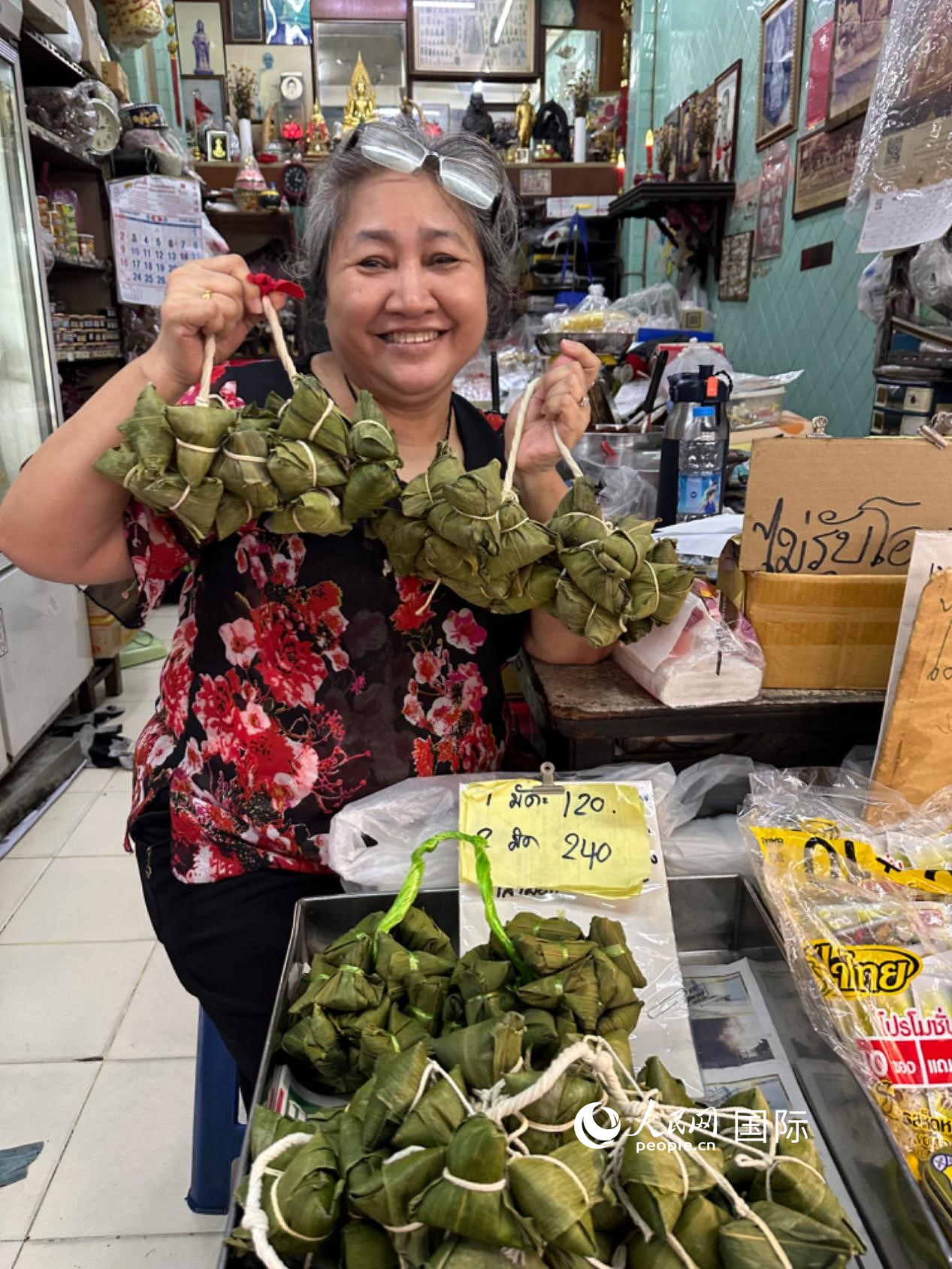 商家向顧客介紹“吉掌”（粽子的一種，一串一串，個頭較小）。人民網(wǎng)記者 簡承淵攝