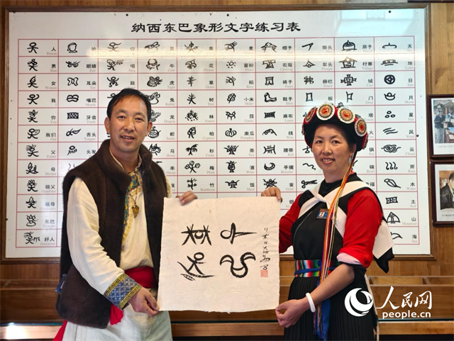 人民網(wǎng)“行進中國”云南調(diào)研采訪團走進麗江，和閏元現(xiàn)場用東巴文寫下“行進中國”。人民網(wǎng)記者 符皓攝
