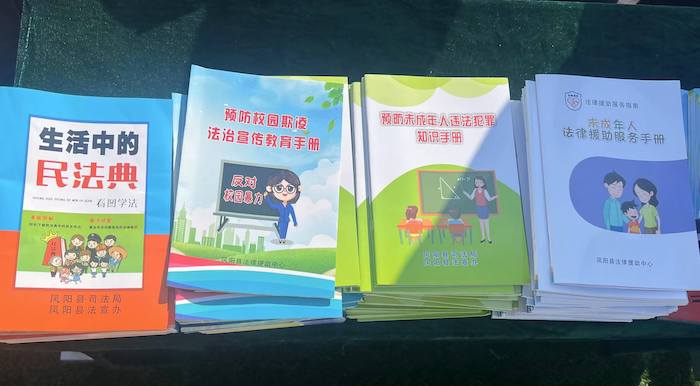 有關部門分發(fā)的普法宣傳冊。人民網 高清揚攝