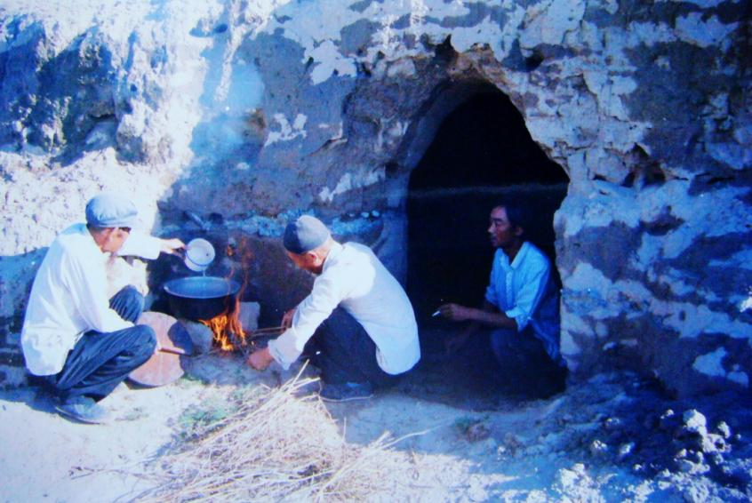 1983年，“六老漢”一代治沙人在“地窩子”生活做飯。新華社發(fā)（八步沙林場供圖）
