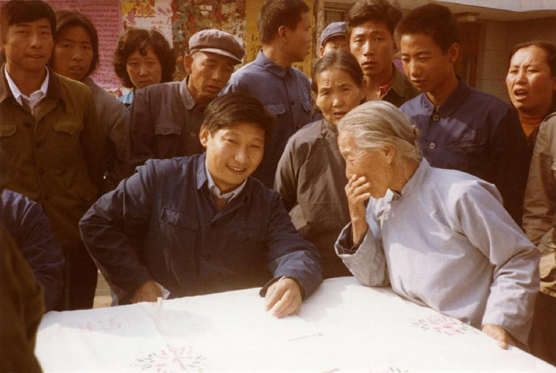 1983年，時(shí)任河北正定縣委書記的習(xí)近平（前排居中），臨時(shí)在大街上擺桌子聽取老百姓意見。