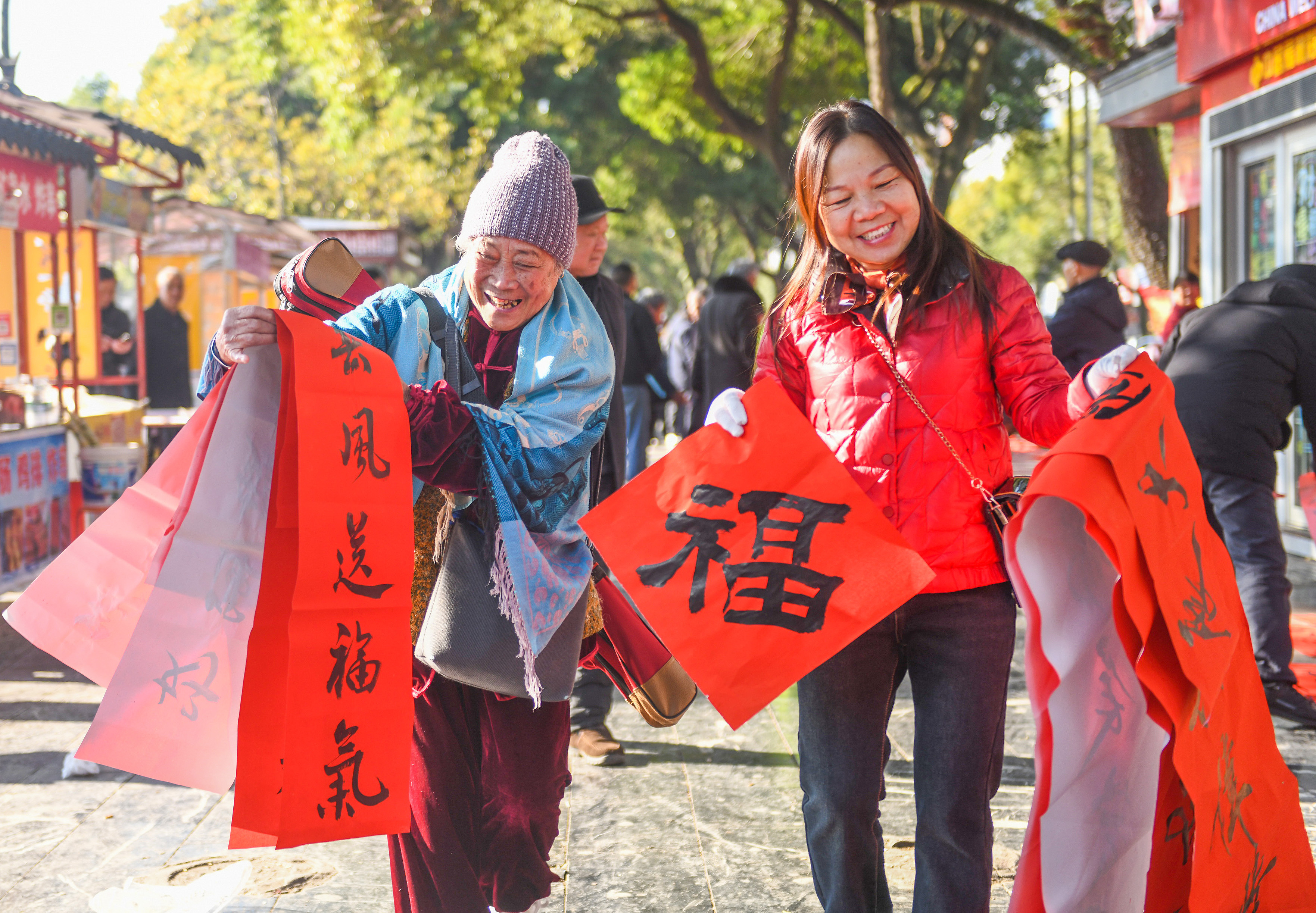 2025年1月13日，在湖南省永州市道縣西洲公園義工崗亭，市民們領到了書法志愿者為大家書寫的春聯(lián)。
