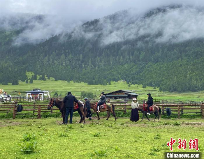 6月10日，游客在魯朗小鎮(zhèn)高山牧場景區(qū)體驗騎馬。　冉文娟 攝