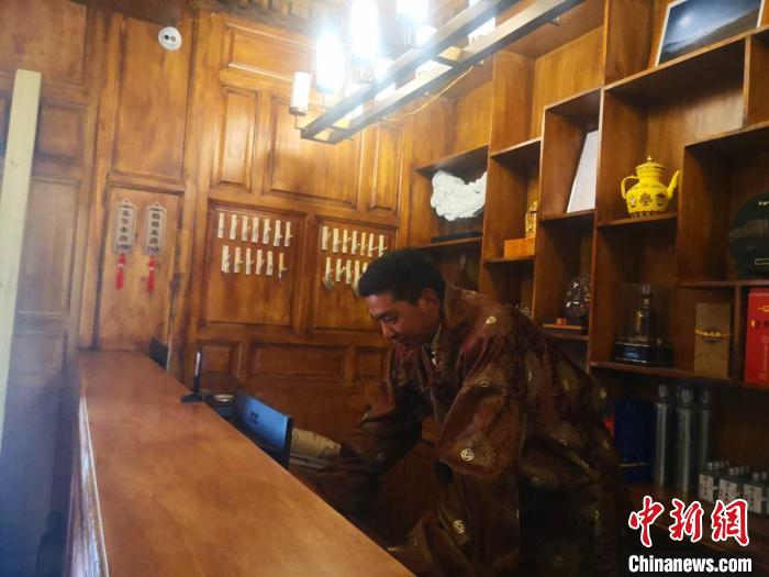 圖為桑杰才讓用電腦處理財務?！∈缝o靜 攝