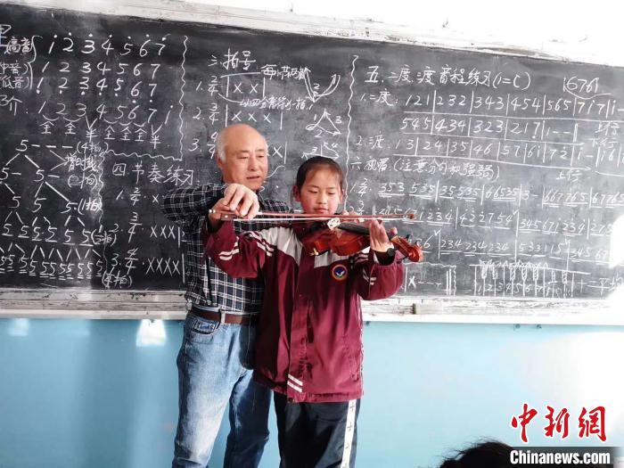 圖為趙興洲教學生拉小提琴。受訪者提供