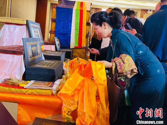 圖為現(xiàn)場(chǎng)藏族民眾向黃金書寫的大藏經(jīng)《甘珠爾》敬獻(xiàn)哈達(dá)?！O睿 攝