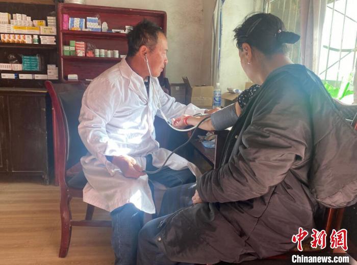 索木滾(左)為村民看病。　壤塘縣委宣傳部供圖