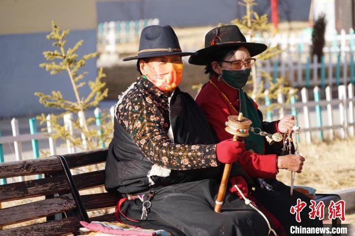圖為敬老院老人在院內(nèi)曬太陽(yáng)轉(zhuǎn)經(jīng)桶。　馬銘言 攝