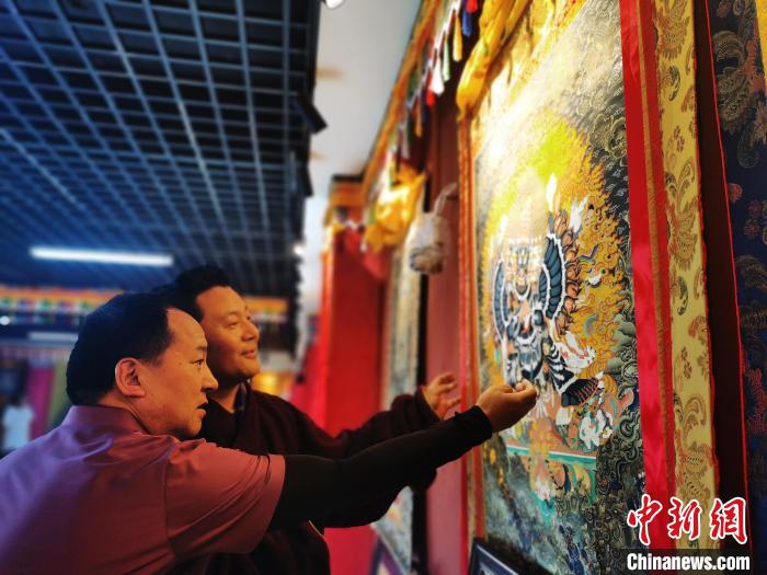 圖為久美尖措展示唐卡作品。　張?zhí)砀?攝