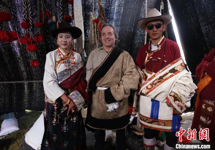 圖為一名外籍?dāng)z影師(中)身穿藏服和藏族民眾合影留念。　馬銘言 攝