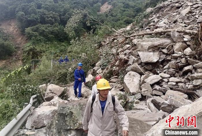 電力搶險(xiǎn)人員徒步通過(guò)垮塌路段。　四川電力供圖