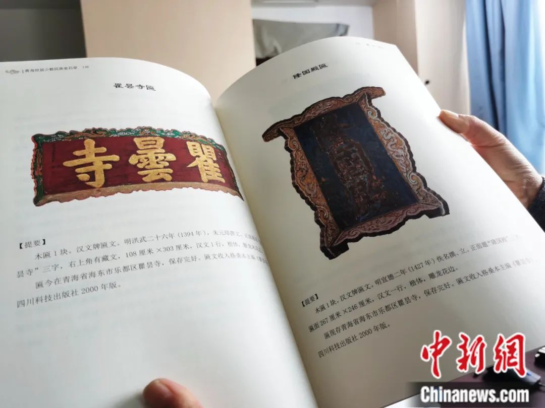 古籍保護(hù)人員展示介紹明代朱元璋撰寫的青海瞿曇寺匾(左)的出版書籍。張?zhí)砀?攝