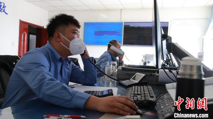 圖為貨運(yùn)調(diào)度人員與外勤工作人員聯(lián)系掌握車輛裝載情況。　李生燕 攝