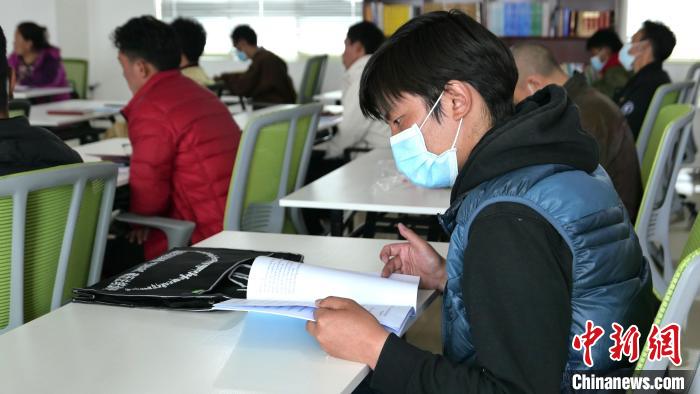 圖為正在閱讀“杰松達(dá)孜”藏歷法教材的學(xué)員。　謝牧 攝