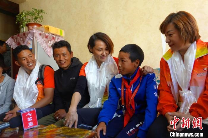 圖為世界冠軍在拉薩進(jìn)行家訪，與青少年運(yùn)動員聊天?！∪轿木?攝