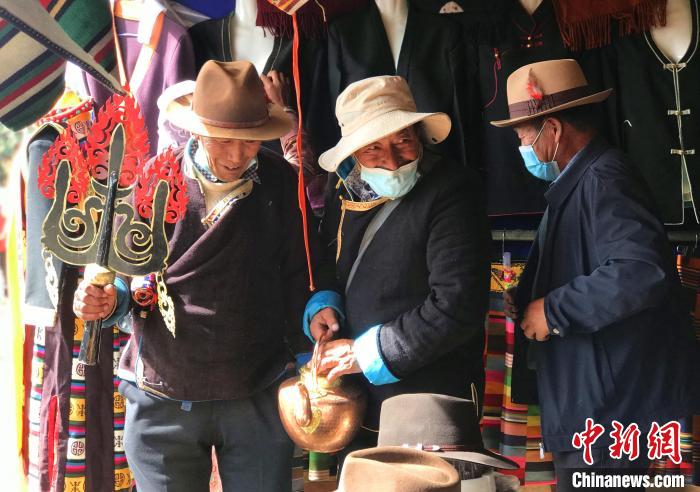 圖為三位藏族老人在集市上聊天交談?！∪轿木?攝