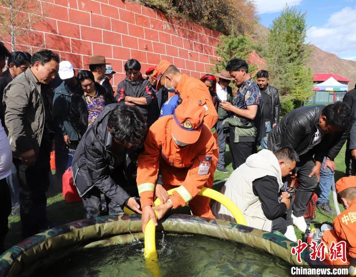 圖為森林消防員為護(hù)林員講解滅火裝備的使用方法。　昌都市森林消防支隊(duì) 供圖