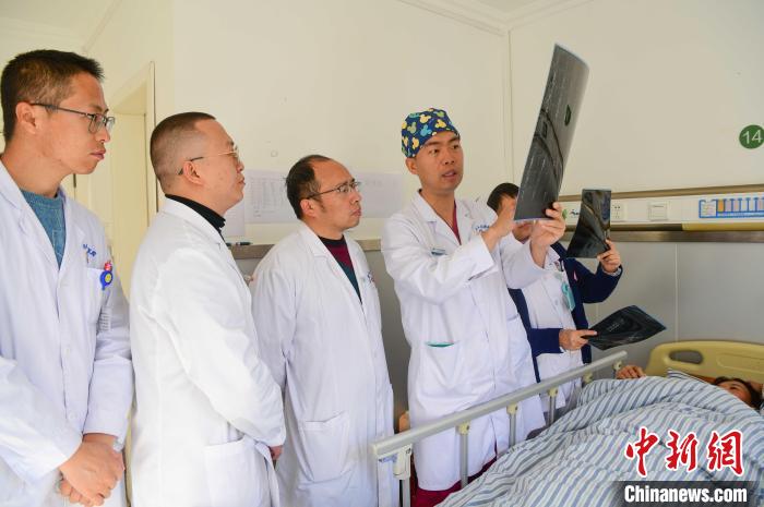 圖為醫(yī)療援藏專家何蔚(站右二)與馮敬云(左二)、廖濤(左三)等人討論患者病情。(資料圖) 貢嘎來松 攝