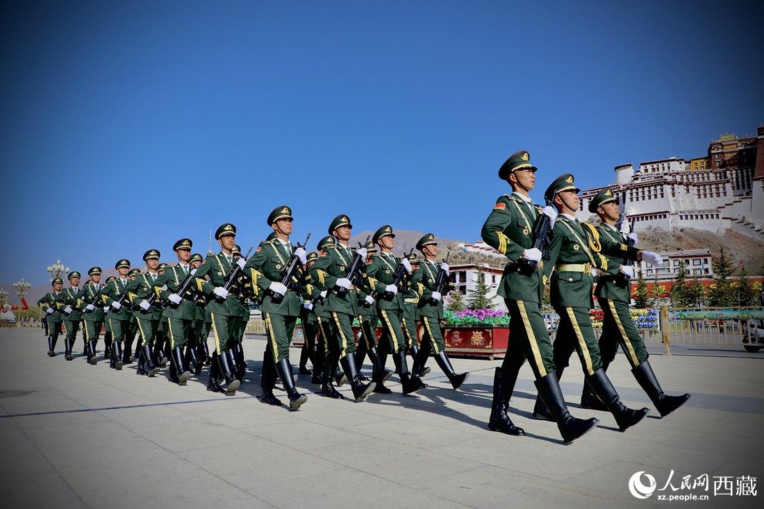 國旗護衛(wèi)隊隊員緊握鋼槍，踏著威武雄壯的步伐，走向國旗臺。人民網(wǎng) 次仁羅布攝