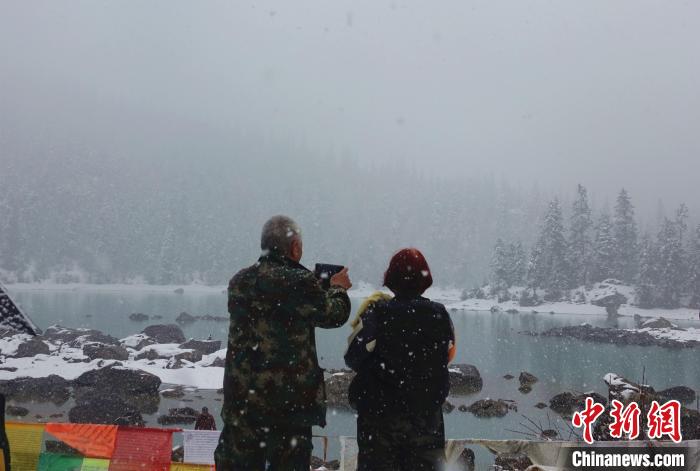 游客欣賞雪中然烏湖。　冉文娟 攝
