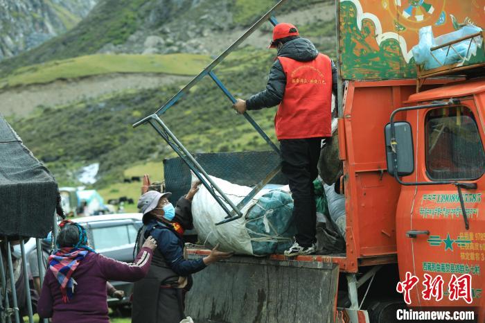 圖為工作人員幫助牧民們卸家具?！÷蹇?攝