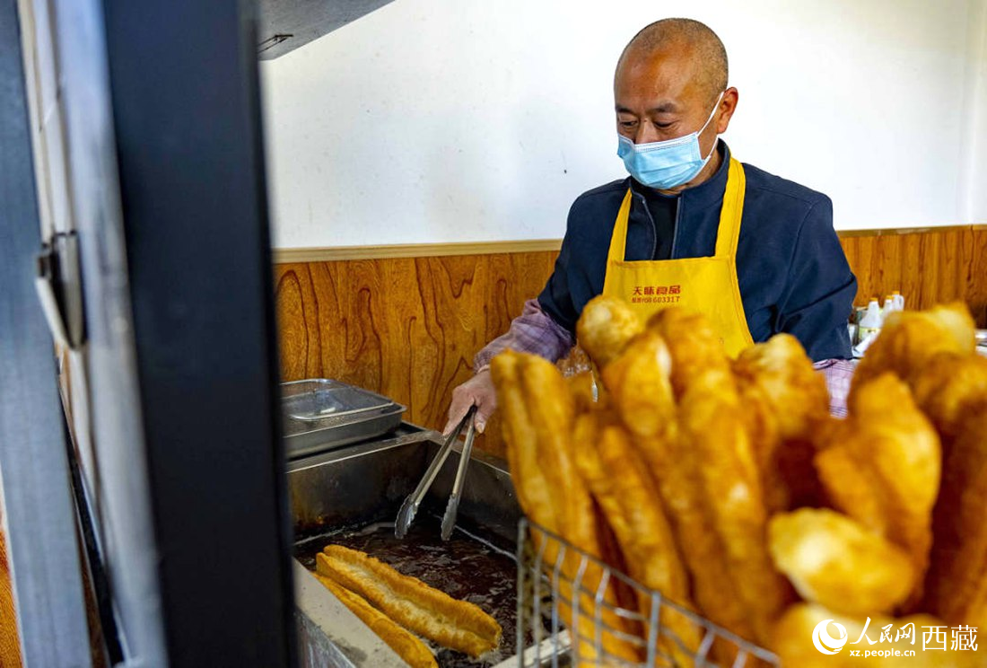 早餐店老板正在炸油條。人民網(wǎng) 次仁羅布攝