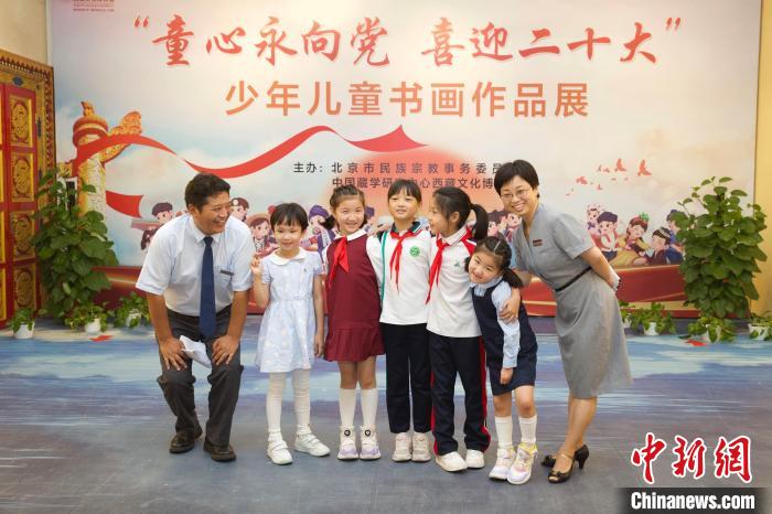 圖為與會嘉賓與入選畫作的“小作者”們在展覽上合影?！≈袊貙W研究中心供圖