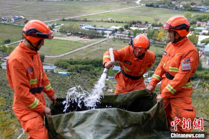 技能大練兵過程中，消防員在陡坡上向蓄水池注水?！±顕鵂c 攝