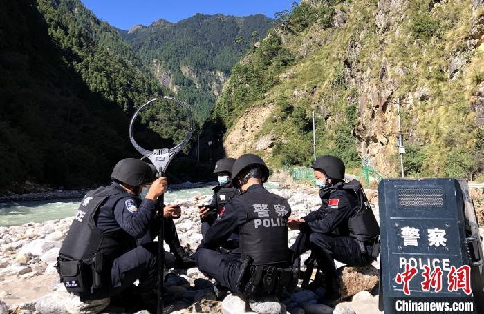 圖為西藏吉隆出入境邊防檢查站移民管理警察在中尼邊境巡邏途中收看二十大開幕直播。　郭章統(tǒng) 攝