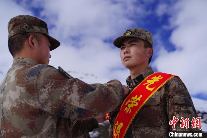 排長王朝偉(圖左)給退伍老兵佩戴大紅花?！∥鞑厣侥宪姺謪^(qū)某團供圖