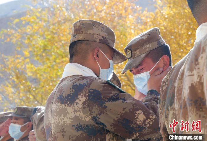 圖為什布奇邊防連退伍老兵與戰(zhàn)友相擁而泣，依依惜別?！⌒觳?攝