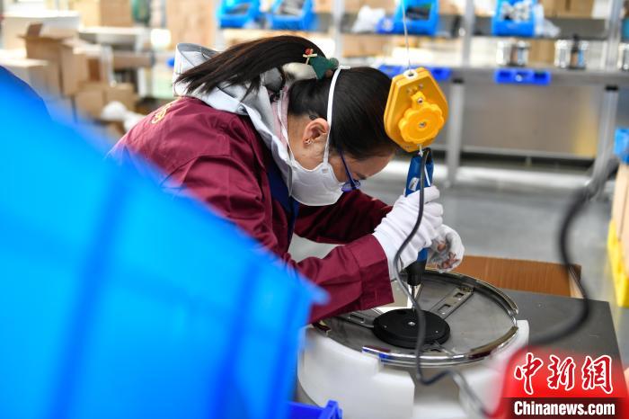 圖為工人正在組裝炊具?！∝暩聛硭?攝