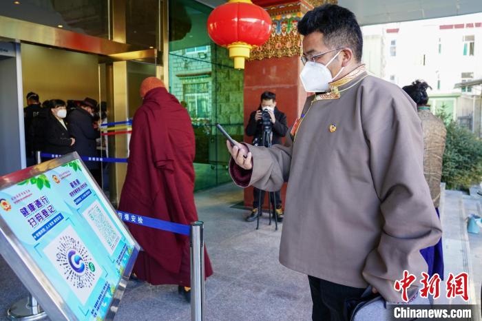 圖為政協(xié)委員掃場所碼進(jìn)入會場?！〗w波 攝