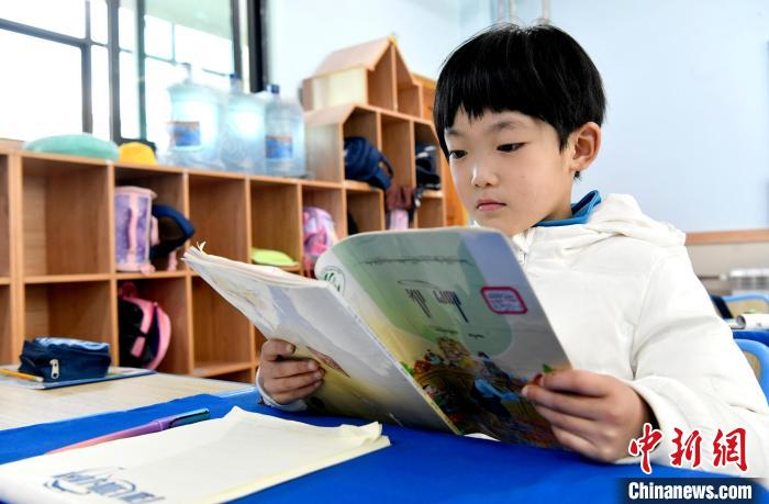3月14日，西藏拉薩市第一小學(xué)一年級(jí)六班學(xué)生丁增樂吉在閱讀藏語課本?！±盍?攝