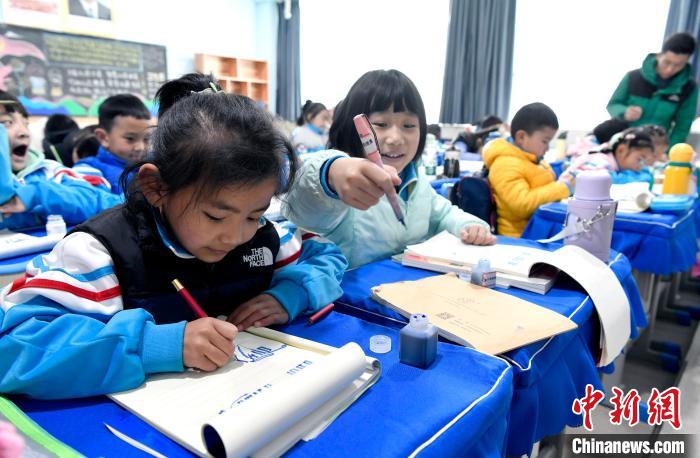 3月14日，西藏拉薩市第一小學(xué)一年級(jí)六班學(xué)生白瑪朗珍(圖左)在藏語文課上書寫藏文。　李林 攝
