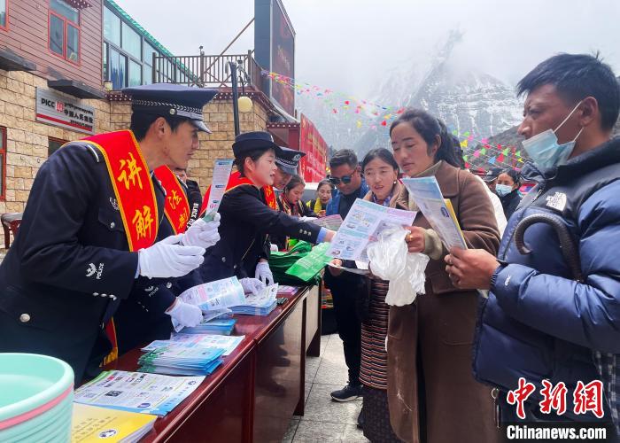 圖為山南玉麥邊境派出所民警為轄區(qū)群眾發(fā)放法律知識宣傳單?！＄婗?　攝