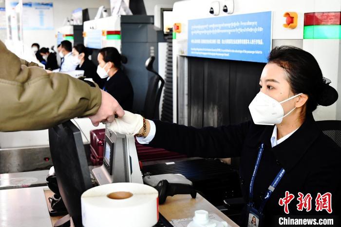 圖為機(jī)場工作人員為旅客辦理行李托運(yùn)?！≈芎?攝
