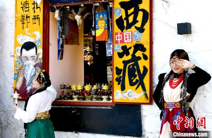 4月17日，游客身著藏式元素服裝在拉薩八廓街拍照留念?！±盍?攝