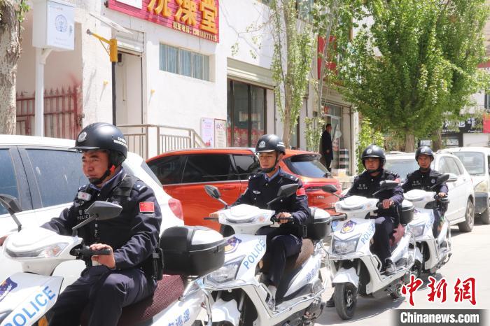 民警騎著電瓶車在轄區(qū)巡邏走訪。　黃創(chuàng)偉 攝