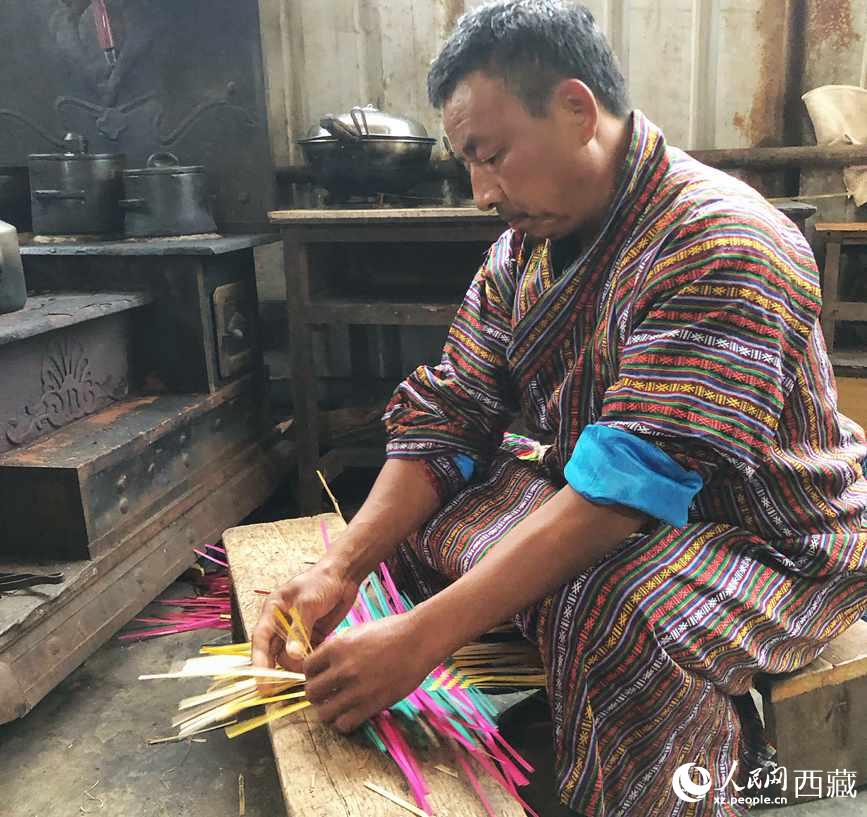 門巴族漢子愛明正在編織藤竹品。