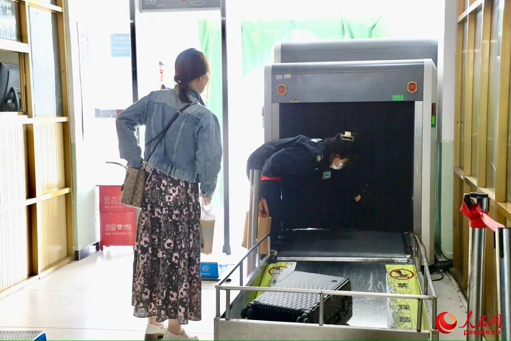 車站工作人員幫旅客提取行李。人民網(wǎng)記者 次仁羅布攝