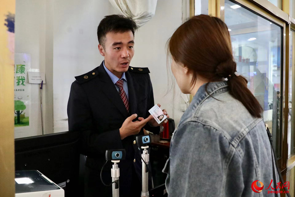 車站工作人員向旅客解答疑問。人民網(wǎng)記者 次仁羅布攝