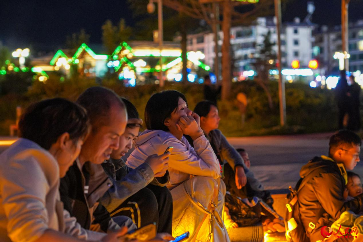 市民坐在西藏林芝市民族團(tuán)結(jié)廣場(chǎng)臺(tái)階上欣賞音樂噴泉。人民網(wǎng)記者 趙晨攝