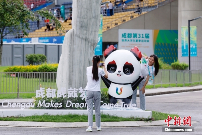志愿者在比賽場(chǎng)館外與吉祥物景觀合影。<a target='_blank' href='/'><p  align=